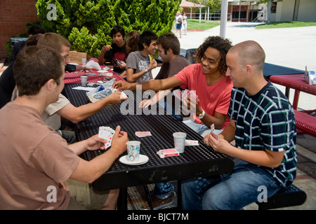 Hispanic und weißen Southern California High School Jungen spielen Karten in der Mittagspause auf dem Campus. Stockfoto