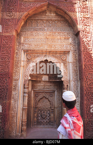 Muslimische Jungen beobachten Islamische Ornamentik des Quran Inschrift auf Qutab Minar geschnitzt; Indo-islamischen Kunst; Delhi-Sultanats; Indien Stockfoto