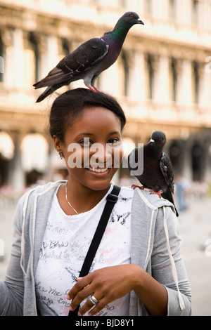 Junge Frau mit Vögel auf ihren Kopf und Schulter. Stockfoto