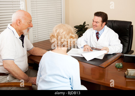 Arzt diskutieren Behandlungsmöglichkeiten mit einem älteren Ehepaar in seinem Büro. Stockfoto