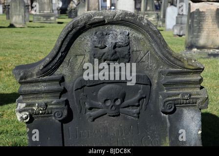 Ein Grabstein aus dem 18. Jahrhundert mit einem „grünen Mann“ und Schädel und Kreuzknochen in South Leith Parish Churchyard, Leith, Edinburgh, Schottland. Stockfoto