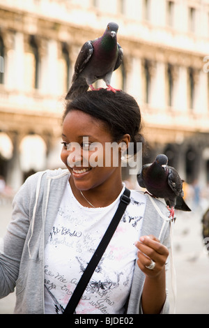 Junge Frau mit Vögel auf ihren Kopf und Schulter. Stockfoto