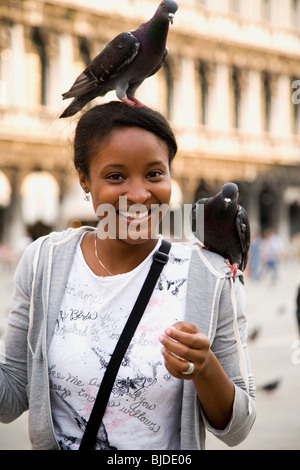 Junge Frau mit Vögel auf ihren Kopf und Schulter. Stockfoto