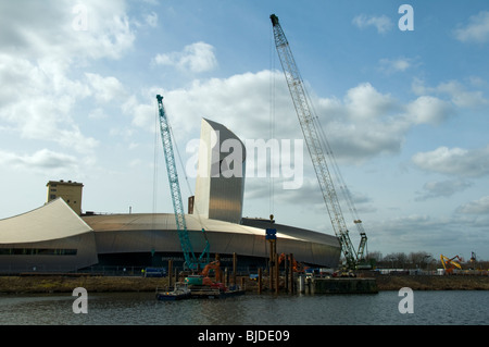 Rammarbeiten Betrieb, mit einem Vibrations Ramme außerhalb Imperial War Museum North in Salford Quays, Manchester, UK Stockfoto