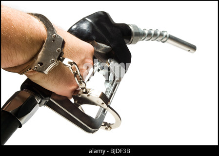 Hand mit Handschellen gefesselt an einer Zapfsäule. Stockfoto