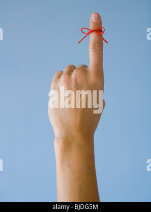 Frau mit einer roten Schnur an ihrem Finger. Stockfoto