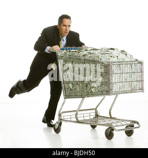 Unternehmer mit einem Einkaufswagen voller Geld Stockfoto