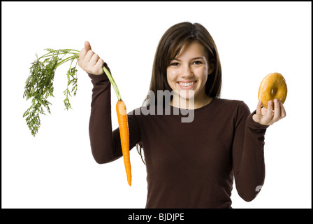 junge Frau die Wahl zwischen einer Karotte und einen donut Stockfoto