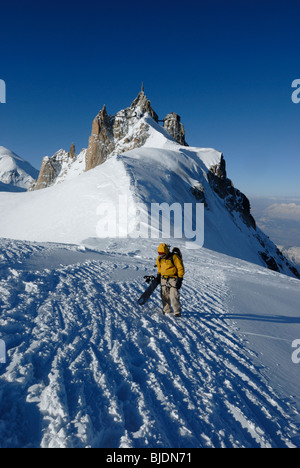 Snowboarder Wandern auf schmalen Grat von Aiguille du Midi in Richtung Le Vallée Blanche, Chamonix, Frankreich Stockfoto