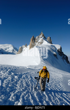 Snowboarder Wandern auf schmalen Grat von Aiguille du Midi in Richtung Le Vallée Blanche, Chamonix, Frankreich Stockfoto