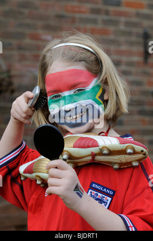 Jungen Fußball Fan Mädchen tragen rote England t-Shirt mit Gesicht gemalt in den Farben der Nationalflagge der Republik Südafrika Stockfoto