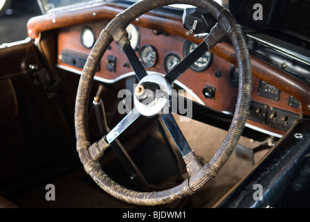 Ein Lenkrad von einem alten klassischen Auto (Holz-Armaturenbrett) Stockfoto