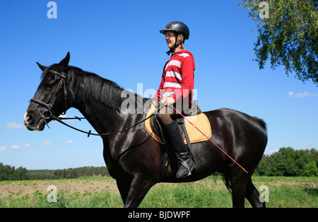 Teenager-jungen schwarzen Hengst Reiten Stockfoto