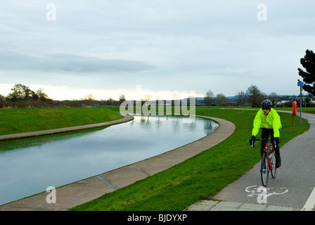 Radfahrer auf dem Radweg neben der Wasserstraße Stockfoto