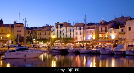 Cassis, Provence, Frankreich. Blick über den beleuchteten Hafen in der Abenddämmerung. Stockfoto