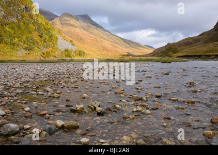 Glen Nevis, Highland, Schottland. Blick über das Wasser Nevis an sonnigen Berghängen, Herbst. Stockfoto