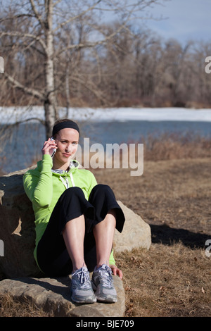 Junge Frau in legerer Kleidung im Freien mit Smartphone Stockfoto