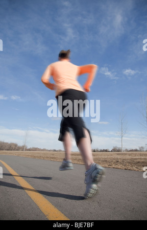 Frau läuft durch den Stadtpark, verschwommen Bewegung Stockfoto