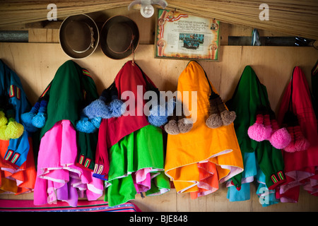 Auf schwimmenden Inseln der Uros, traditionelle peruanische (Bolivien) Kleidung in einem Haus, Altiplano, Puno, Titicacasee, Peru Südamerika Stockfoto