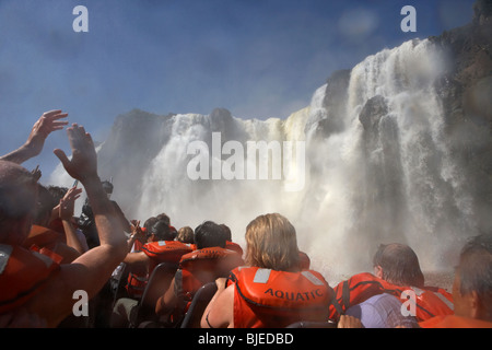 Gruppe von Touristen durchnässt auf dem Schnellboot unter Mbigua Herbst Wasserfälle Iguazu Nationalpark der Argentinischen Republik Stockfoto