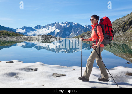 Frau an einem Bergsee, Zillertaler Alpen in der Seitenansicht Hintergrund, Tirol, Österreich, Wandern Stockfoto