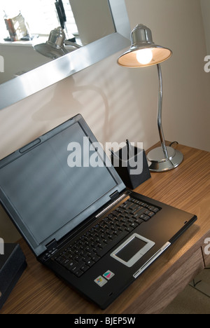 Laptop-Computer mit leeren Bildschirm auf kleinen Schreibtisch mit leichten Schreibtisch im home office Stockfoto