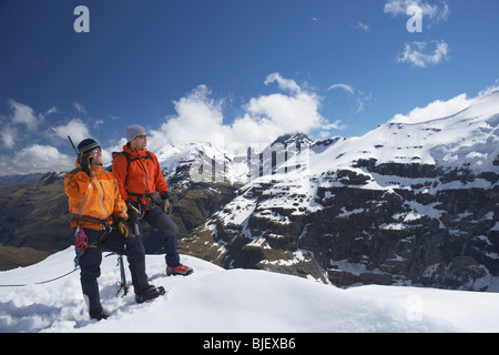 Zwei Bergsteiger am schneebedeckten Gipfel Stockfoto