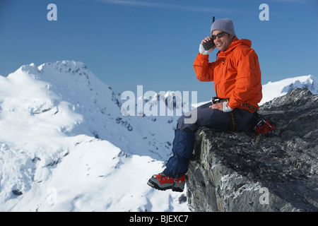 Bergsteiger mit Walkie-talkie auf Berggipfel Stockfoto
