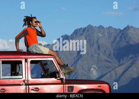 Augen des Mannes Schattierung auf Jeep in der Nähe von Bergen Stockfoto