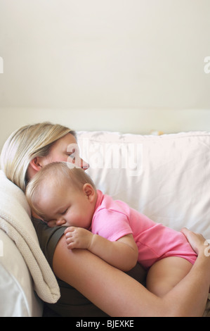 Mutter und Baby schläft auf Sofa Stockfoto