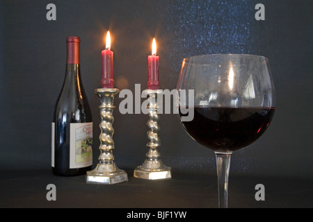 Eine Flasche und Glas Pino Noir und brennenden Kerzen in ein romantisches Ambiente Stockfoto