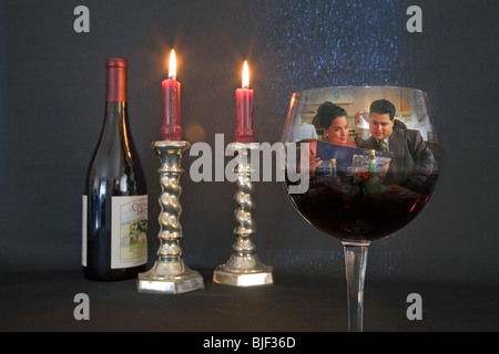 Eine Flasche und Glas Pino Noir und brennenden Kerzen in ein romantisches Ambiente Stockfoto