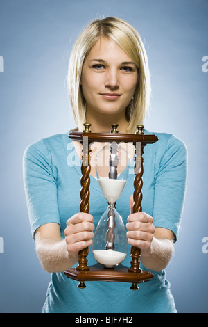 Frau hält eine Sanduhr Stockfoto