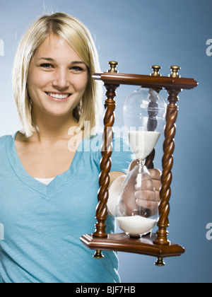 Frau hält eine Sanduhr Stockfoto