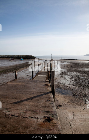 Blick entlang der Slipanlage und Steg bei Ebbe am Rhos auf Meer, Nordwales Stockfoto