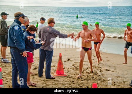 Rettungsschwimmer-Teilnehmer in Laguna Beach, Kalifornien, kommen an Land nach dem fern-qualifizierende schwimmen in kaltem Wasser 53 Grad Stockfoto