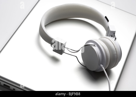 Weiße Eleganz Headfones isoliert auf einem Aluminium-Laptop. Stockfoto