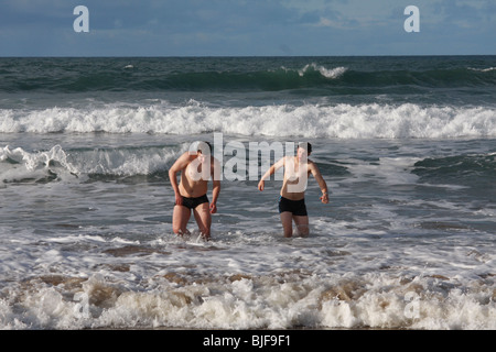 Am Weihnachtstag Schwimmer Schwimmen am Crooklets Strand, Bude, Cornwall. Stockfoto