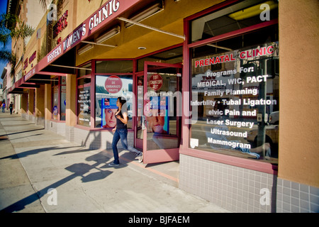 Ein Schaufenster Womens Klinik listet Dienste in Englisch und Spanisch oder "Spanglish" Fenster Zeichen in ein "Barrio" in Kalifornien Stockfoto