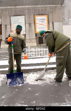Öffentliche Bedienstete Schneeschaufeln in von der New York Public Library, New York City, Square Times, Februar 2010 Stockfoto