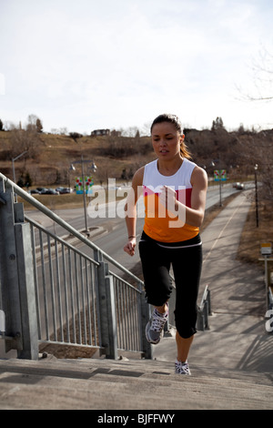 Fit, entschlossene junge Frau im Training Kleidung, laufen/Joggen, Betontreppen in Stadt/städtische Umwelt. Stockfoto