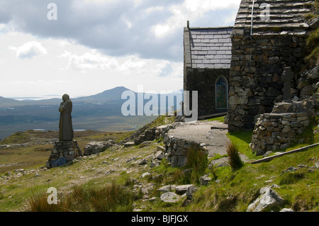 Statue des Heiligen Patrick und die Kapelle, Maumeen Pass, Maumturk Mountains, Connemara, County Galway, Irland Stockfoto