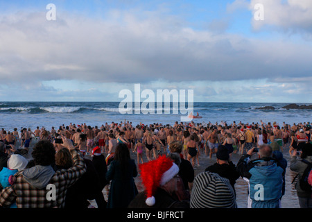 Weihnachtstag Schwimmen am Crooklets Strand, Bude, Cornwall. Stockfoto