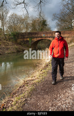 Männliche Walker auf dem Treidelpfad von Basingstoke Canal von Broak Oak Bridge in der Nähe von Krönungsfeierlichkeiten, Hampshire, Uk Stockfoto