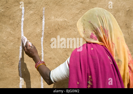 Indische Frau malt ihr Haus. Khuri Dorf. In der Nähe von Jaisalmer. Rajasthan. Indien Stockfoto