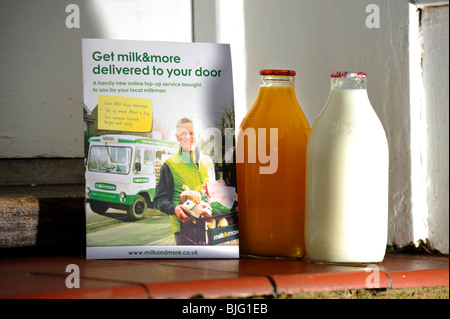 Flaschen Milch und Orangensaft vor einer Haustür geliefert von Milchmann UK Stockfoto