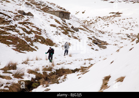 Winterwandern auf Bleaklow in Derbyshire Peak District. Absteigende oberen Norden Getreide durch die Dreharbeiten Kabine Stockfoto