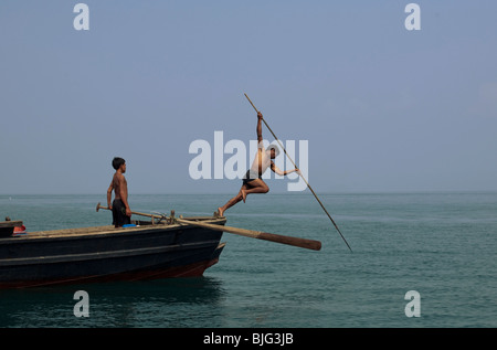 Myanmar-Seezigeuner, die nomadische Jäger und Sammler der Süd-Ost Asien harpunieren auf traditionelle Weise, springen auf einem Boot. Stockfoto