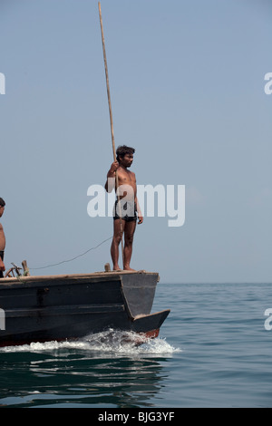 Myanmar-Seezigeuner, die nomadische Jäger und Sammler der Süd-Ost Asien harpunieren auf traditionelle Weise, springen auf einem Boot. Stockfoto