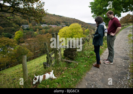 Ein junges Paar Fuß ihren Hund auf den Hügeln oberhalb Hebden Bridge, Yorkshire, England. Stockfoto